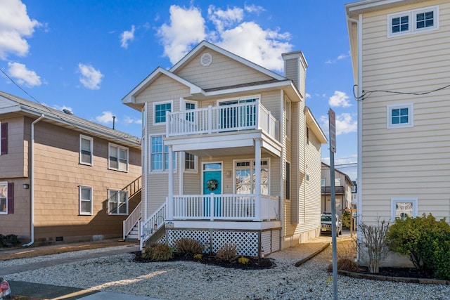 front facade with a balcony and covered porch