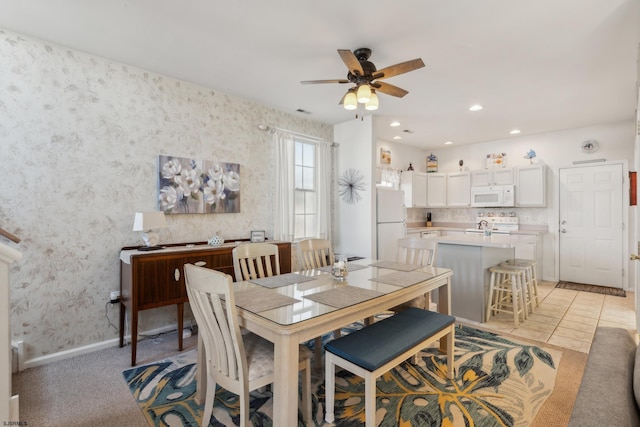 carpeted dining room featuring ceiling fan and sink