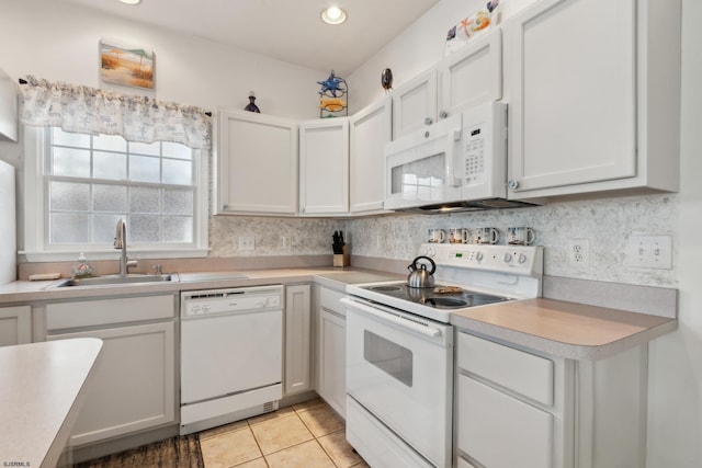 kitchen featuring white cabinetry, sink, and white appliances