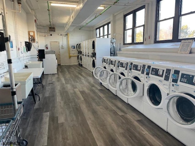 laundry area with dark wood-type flooring, washing machine and clothes dryer, and stacked washer / drying machine