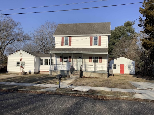 view of front of house with covered porch and a storage shed