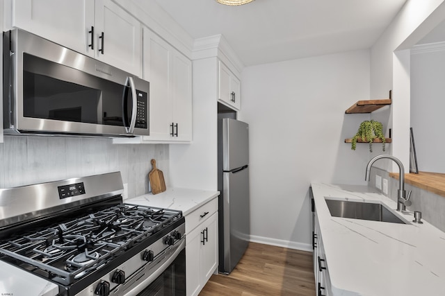 kitchen featuring light stone counters, sink, white cabinets, and appliances with stainless steel finishes