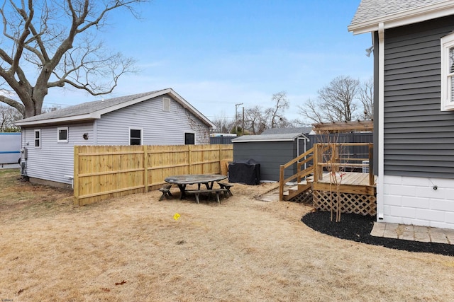 view of yard featuring a wooden deck and a storage shed