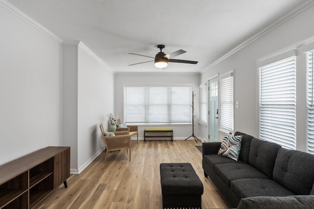 living room with a textured ceiling, ornamental molding, light hardwood / wood-style floors, and ceiling fan