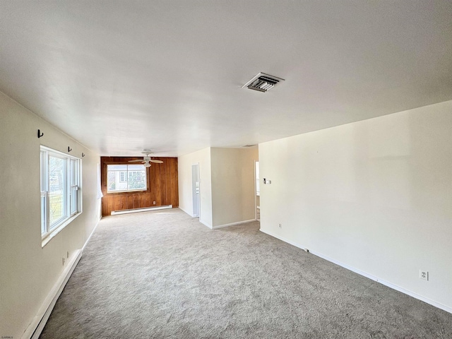 unfurnished living room with baseboard heating, ceiling fan, and carpet