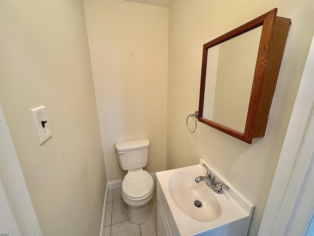 bathroom with tile patterned flooring, vanity, and toilet