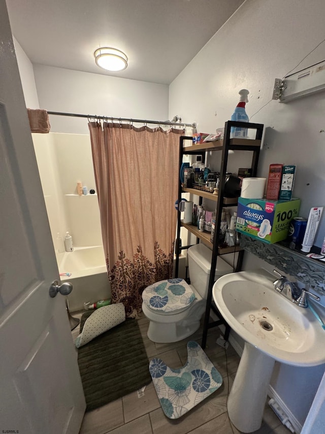 full bathroom with sink, shower / bath combination with curtain, tile patterned floors, and toilet