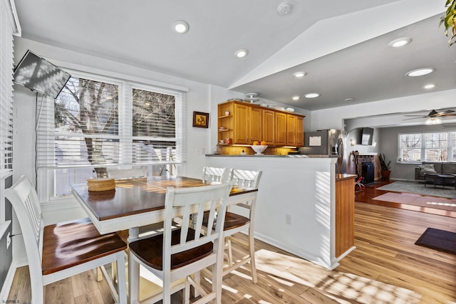 dining room featuring vaulted ceiling, ceiling fan, and light hardwood / wood-style flooring