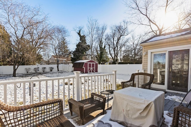 snow covered deck featuring a storage unit