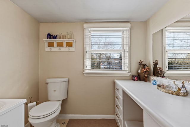 bathroom featuring plenty of natural light, toilet, and vanity