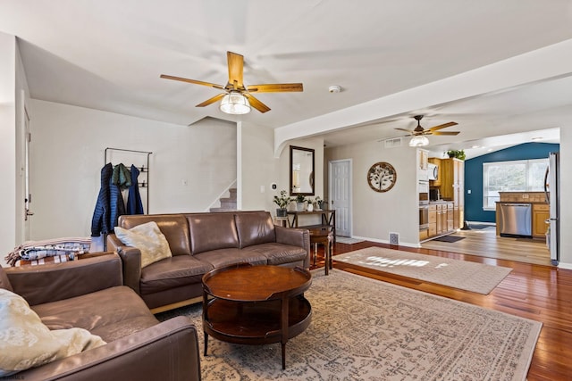 living room with hardwood / wood-style floors, vaulted ceiling, and ceiling fan