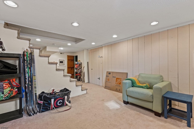 living area with light colored carpet and a textured ceiling