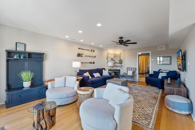 living room with ceiling fan and light hardwood / wood-style flooring