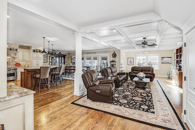 living room featuring ceiling fan, beam ceiling, coffered ceiling, light hardwood / wood-style floors, and ornate columns