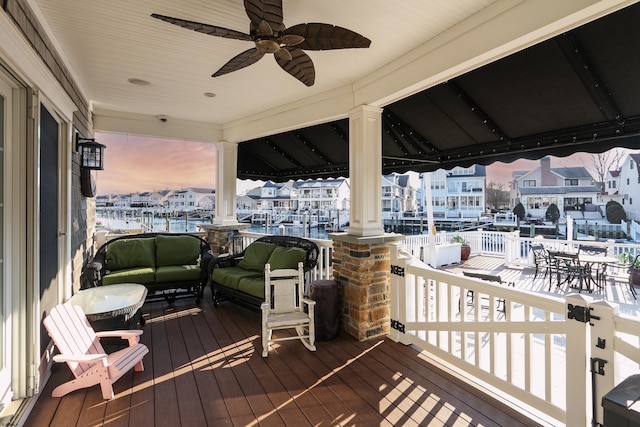 deck at dusk featuring an outdoor living space and ceiling fan