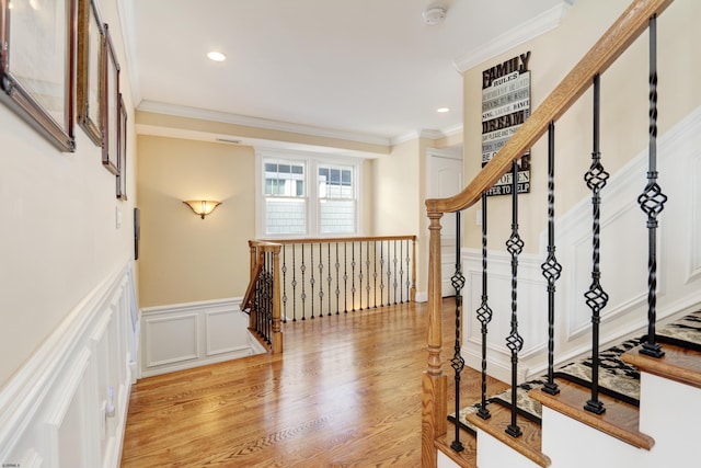 stairs with crown molding and hardwood / wood-style flooring