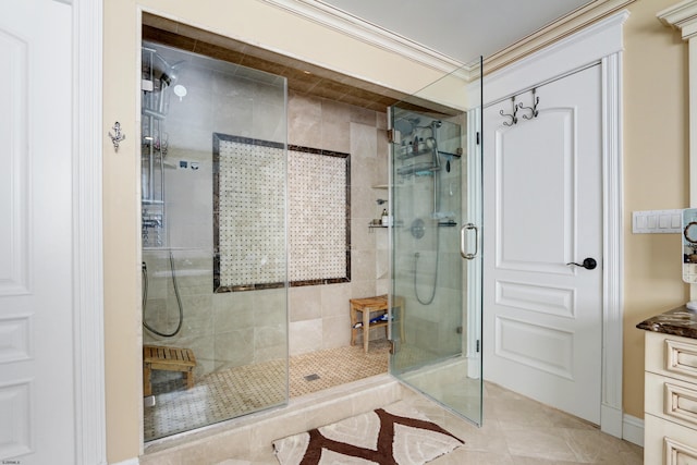 bathroom featuring tile patterned flooring, a shower with shower door, and ornamental molding