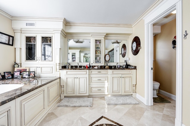 bathroom with ornamental molding, vanity, and toilet