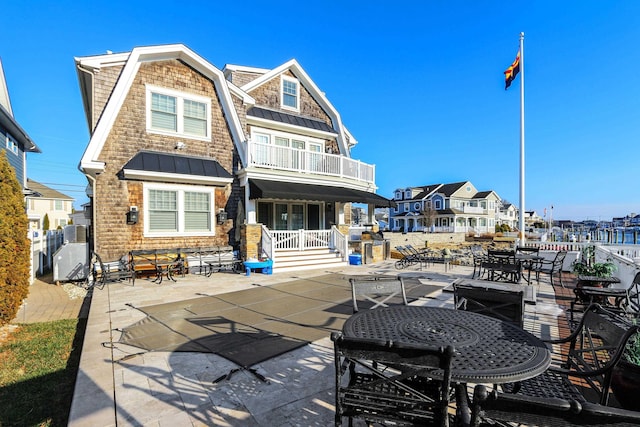 back of property featuring a patio and a balcony