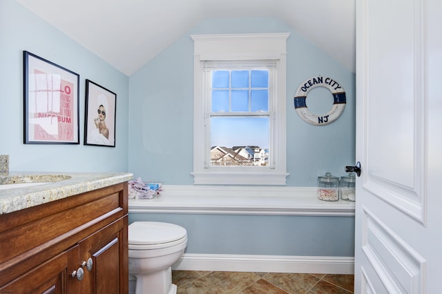 bathroom featuring lofted ceiling, vanity, toilet, and tile patterned flooring