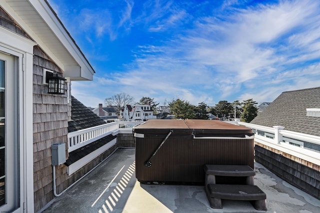 view of patio with a balcony and a hot tub