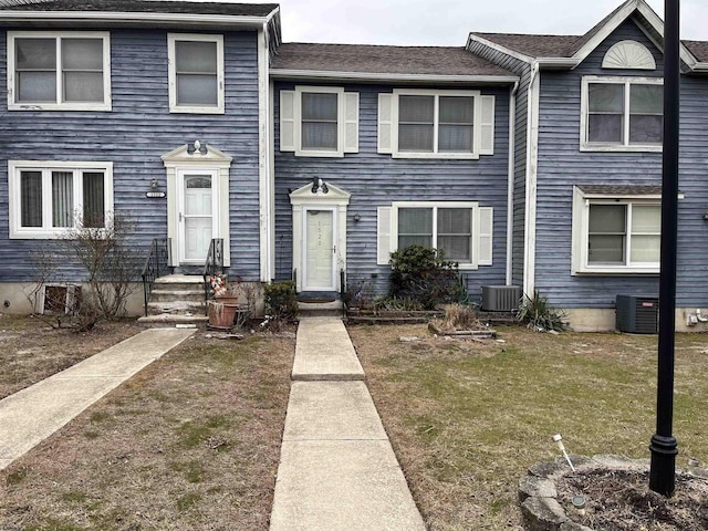 view of property featuring cooling unit and a front yard