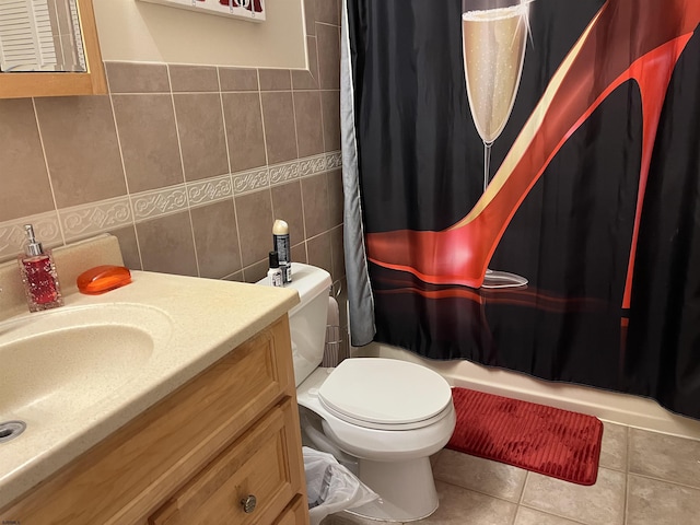 full bathroom with shower / tub combo with curtain, tile walls, tile patterned flooring, vanity, and toilet