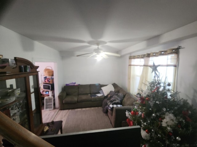 living room with lofted ceiling, hardwood / wood-style floors, and ceiling fan