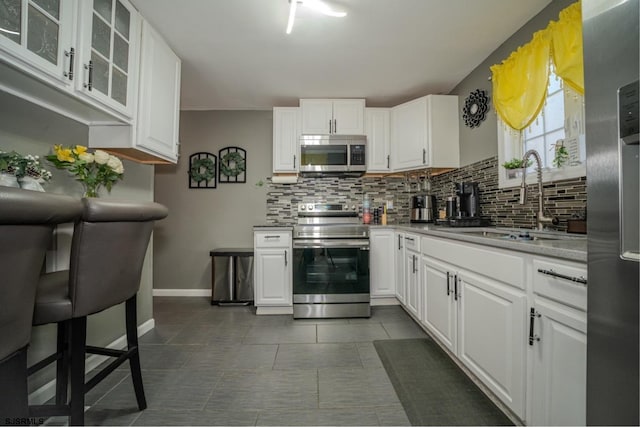 kitchen with white cabinetry, appliances with stainless steel finishes, sink, and decorative backsplash