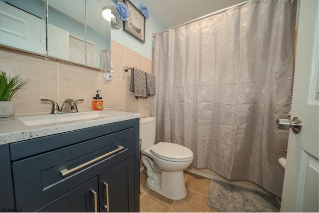 bathroom with tile walls, decorative backsplash, vanity, toilet, and tile patterned floors