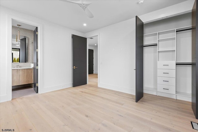 unfurnished bedroom with connected bathroom, light hardwood / wood-style flooring, a closet, and ceiling fan