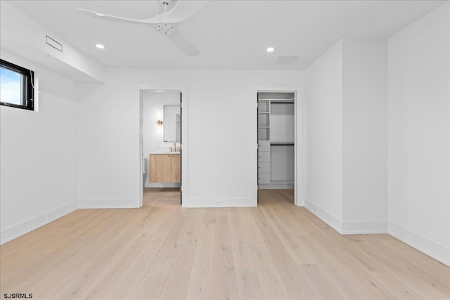 unfurnished bedroom with ceiling fan, connected bathroom, light hardwood / wood-style floors, a walk in closet, and a closet