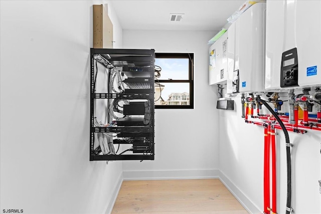 interior space with tankless water heater and light hardwood / wood-style floors