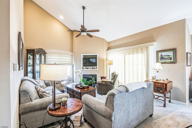 living room with ceiling fan, a healthy amount of sunlight, a fireplace, and high vaulted ceiling