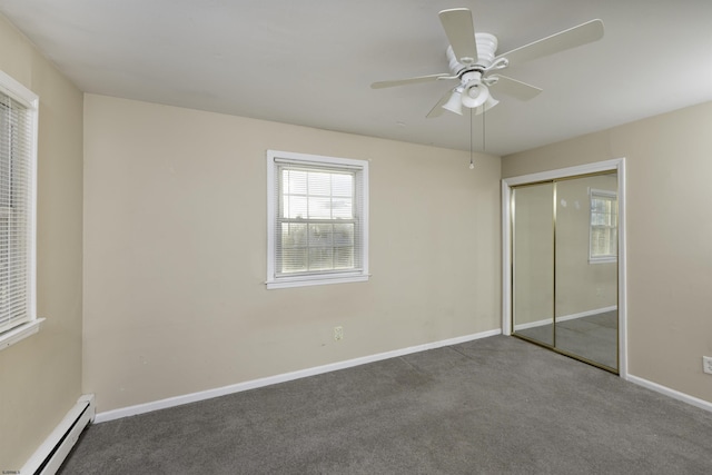 unfurnished bedroom featuring a closet, a baseboard heating unit, ceiling fan, and carpet flooring