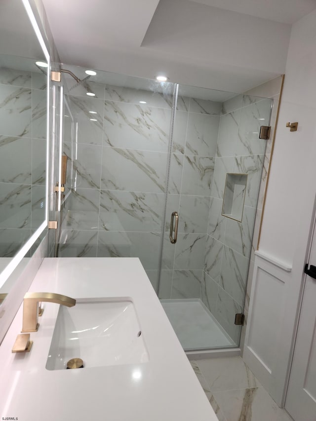 bathroom with vanity and a shower with door