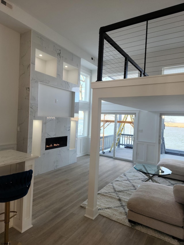 living room featuring hardwood / wood-style flooring, a fireplace, a high ceiling, and a wealth of natural light