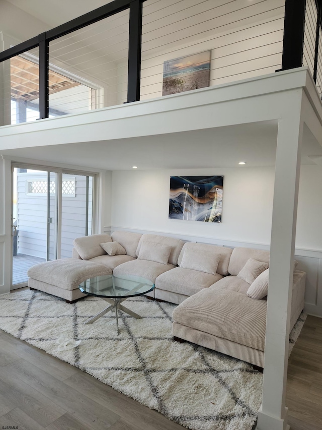 living room with wood-type flooring and a towering ceiling