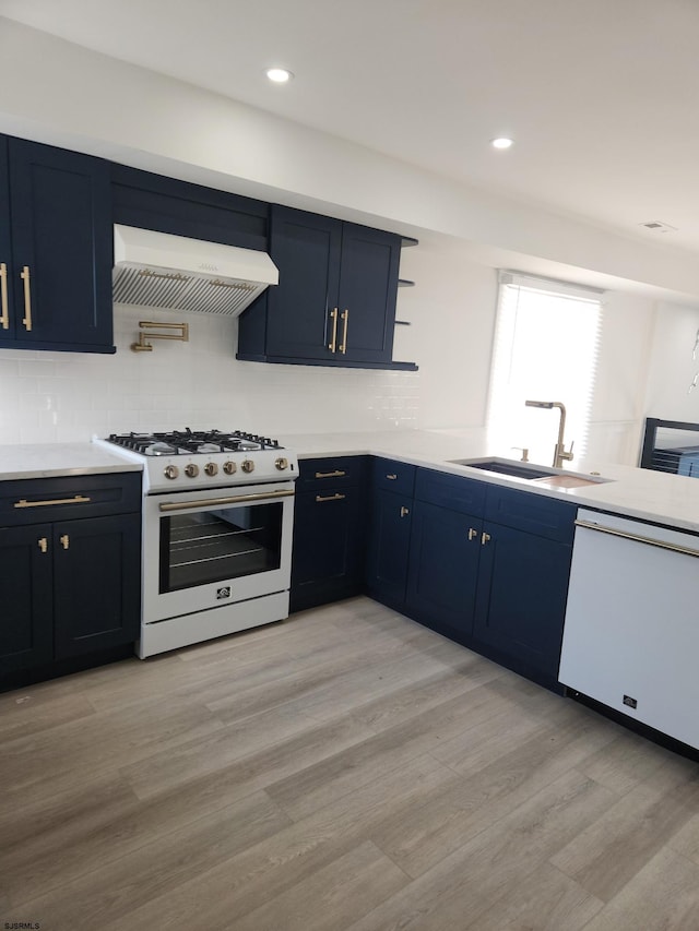 kitchen with sink, exhaust hood, light wood-type flooring, white appliances, and backsplash