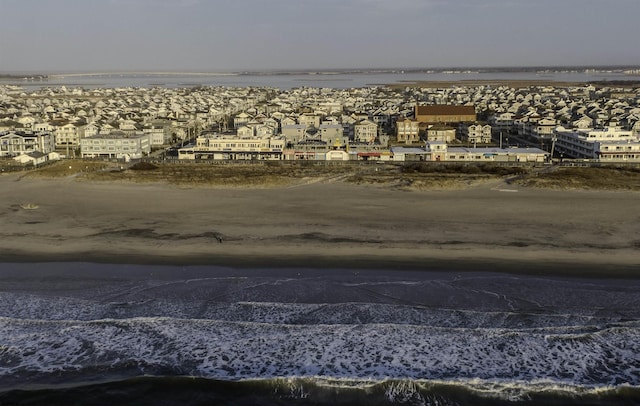 birds eye view of property featuring a water view and a beach view