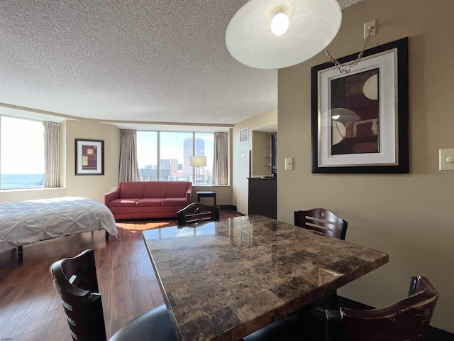 bedroom featuring hardwood / wood-style floors, multiple windows, and a textured ceiling