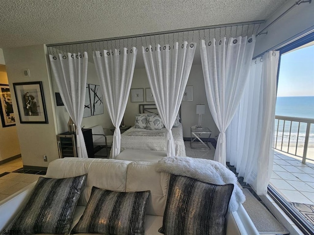 bedroom with a water view and a textured ceiling