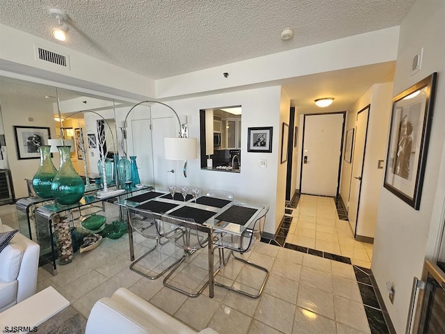 interior space featuring light tile patterned floors and a textured ceiling