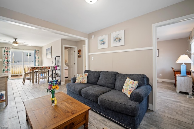 living room featuring wood-type flooring and ceiling fan