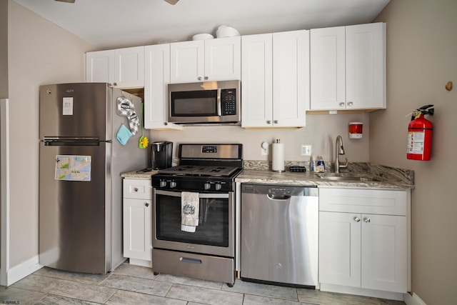 kitchen with white cabinetry, sink, light stone countertops, and appliances with stainless steel finishes