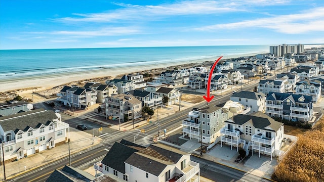 birds eye view of property with a water view and a beach view