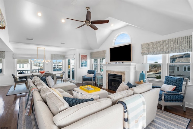 living room with ceiling fan with notable chandelier, dark wood-type flooring, and high vaulted ceiling