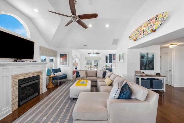 living room with a fireplace, dark hardwood / wood-style flooring, vaulted ceiling, and a wealth of natural light