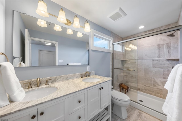 bathroom with vanity, a shower with shower door, and toilet