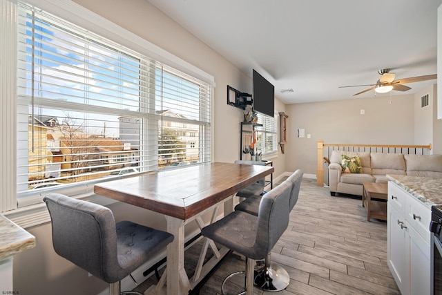 dining area with ceiling fan and light hardwood / wood-style floors